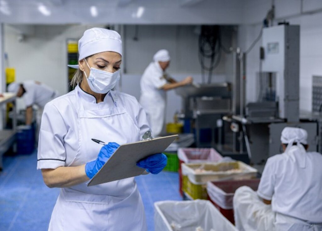 Person checking an industrial kitchen for food safety