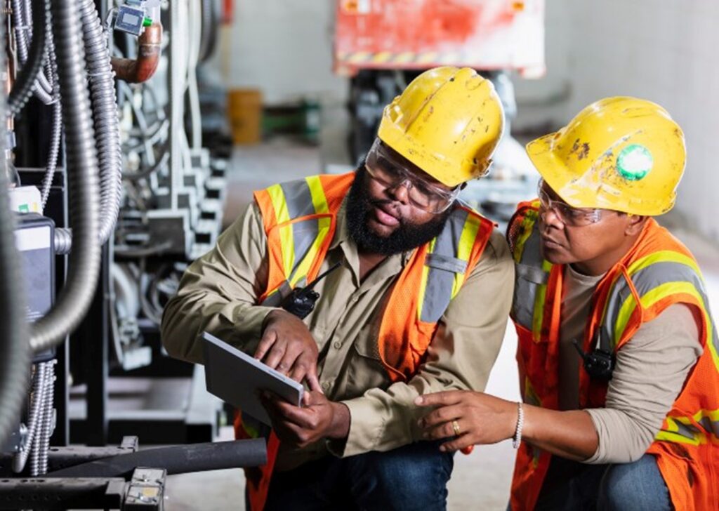 Two workers inspecting industrial machines