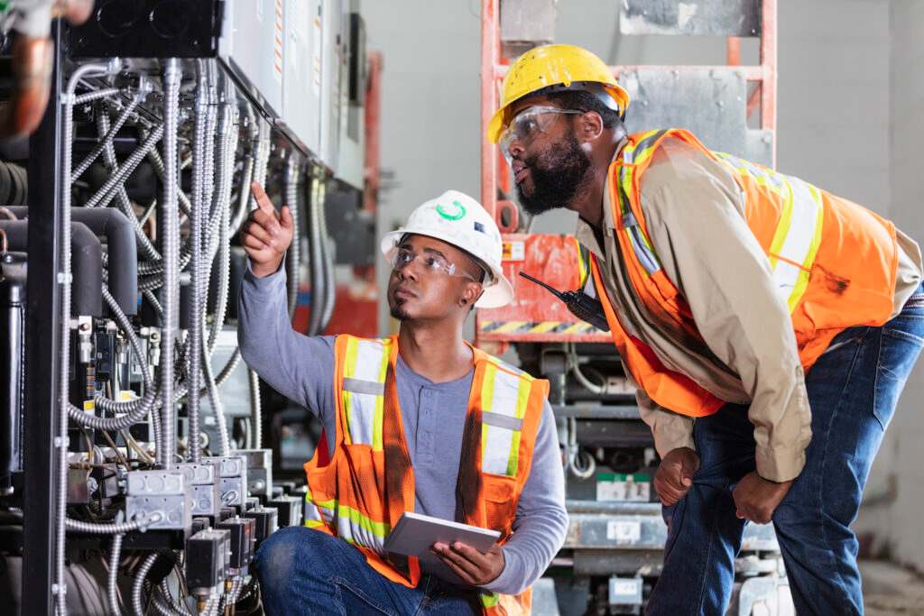 Two technicians are discussing machine repair at the factory located in Danville, VA.