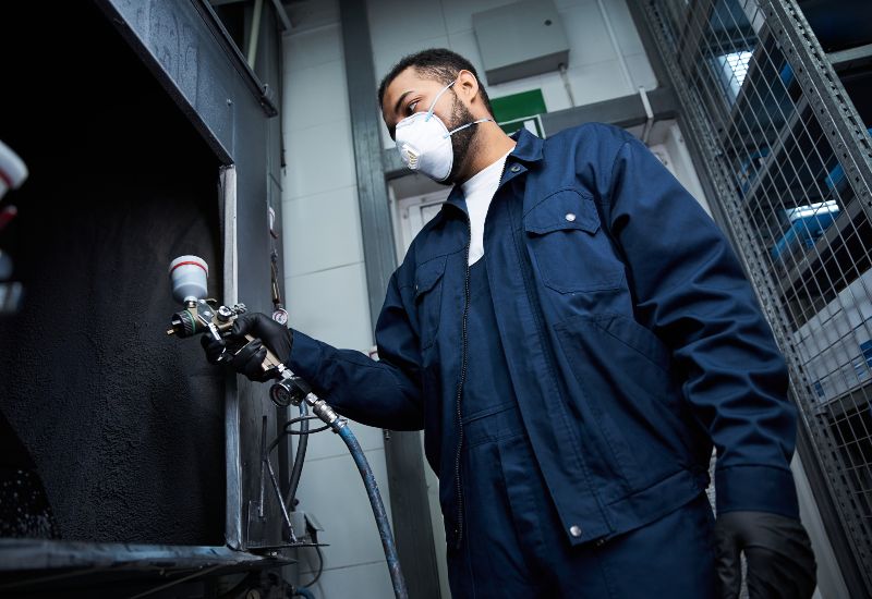 A professional is cleaning a painted booth using spray equipment in Danville, VA