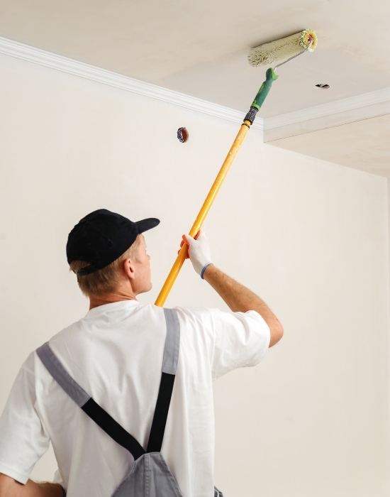 Ceiling painting guide showing a man applying a smooth finish with a roller in the Eastern U.S