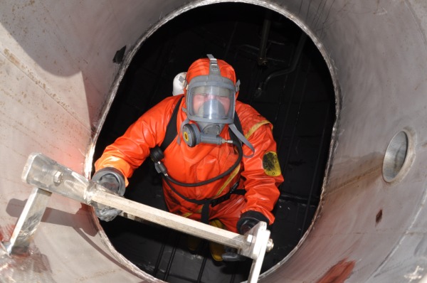 Confined space cleaning worker wearing safety gear